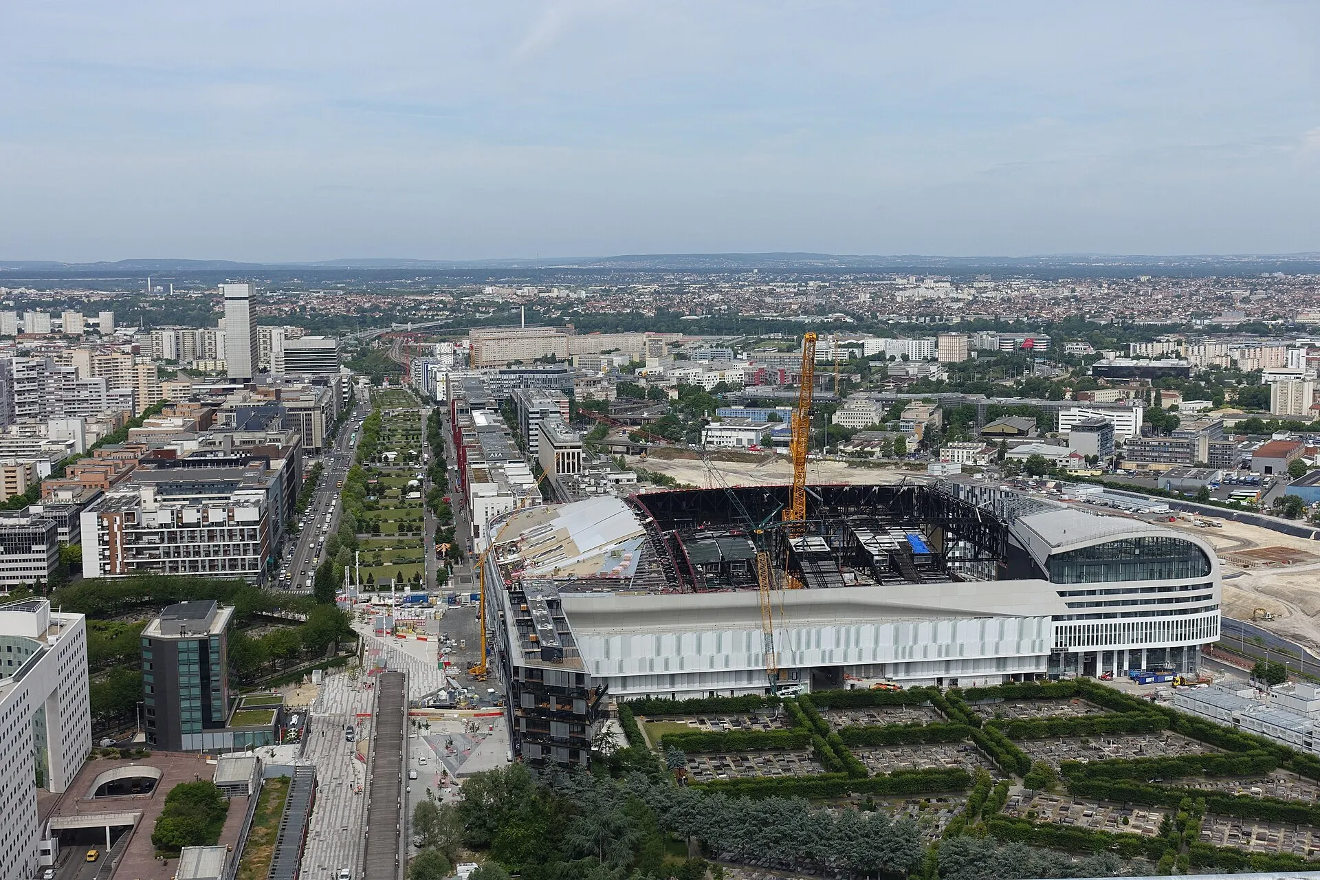 Vue en hauteur, depuis le toit de la Grande Arche de La Défense, de la grande salle de Nanterre (aujourd'hui Plenitude Arena) et des immeubles qui l'entourent.