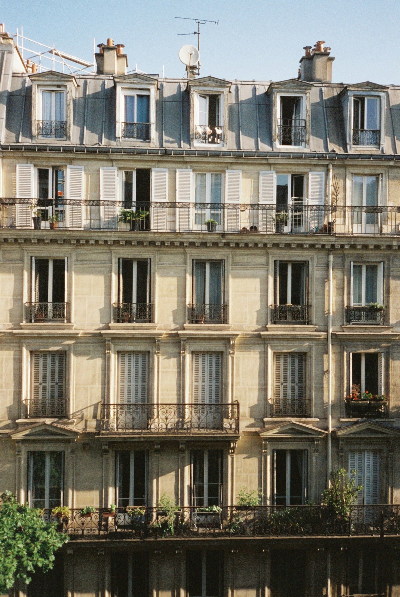 Façade d'un immeuble haussmannien parisien en pierre de taille, vue depuis la rue.