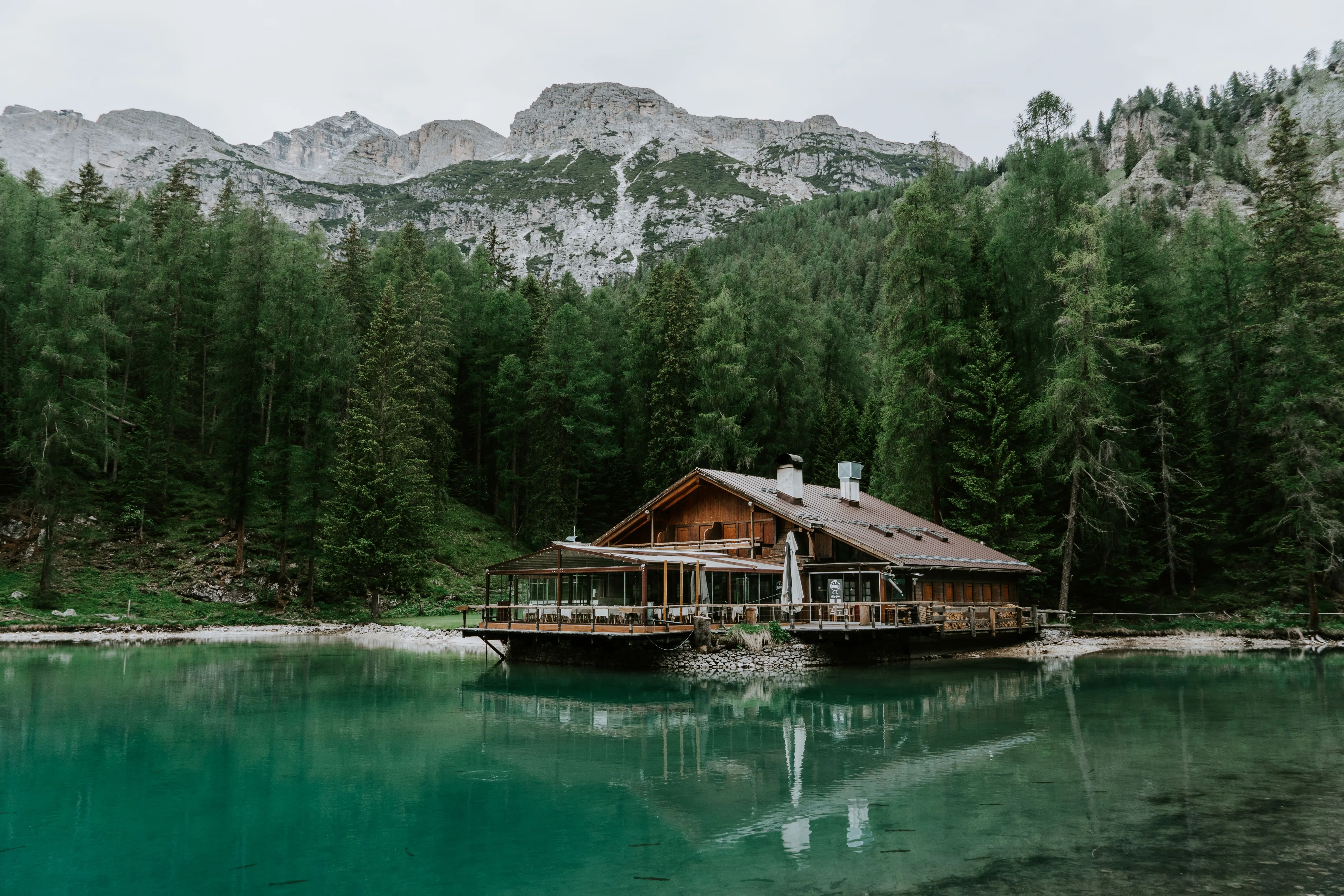 Chalet en bois au bord d'un lac de montagne, entouré de forêt